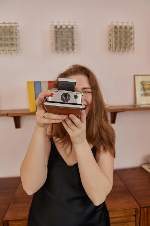 a woman holding a camera in her right hand