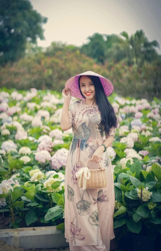 a woman holding a hat standing on a field