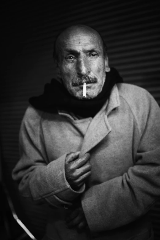 a man with a cigarette in his mouth is posing