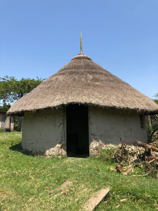 an old hut sits in the grass next to a path