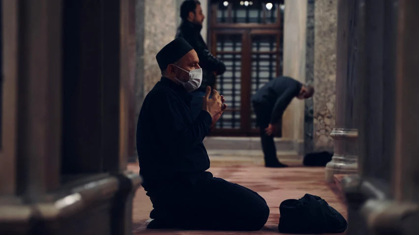 a person sitting on the ground wearing a face mask