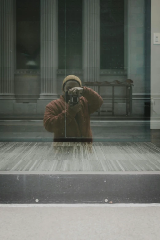 a man taking a po in a glass enclosed area