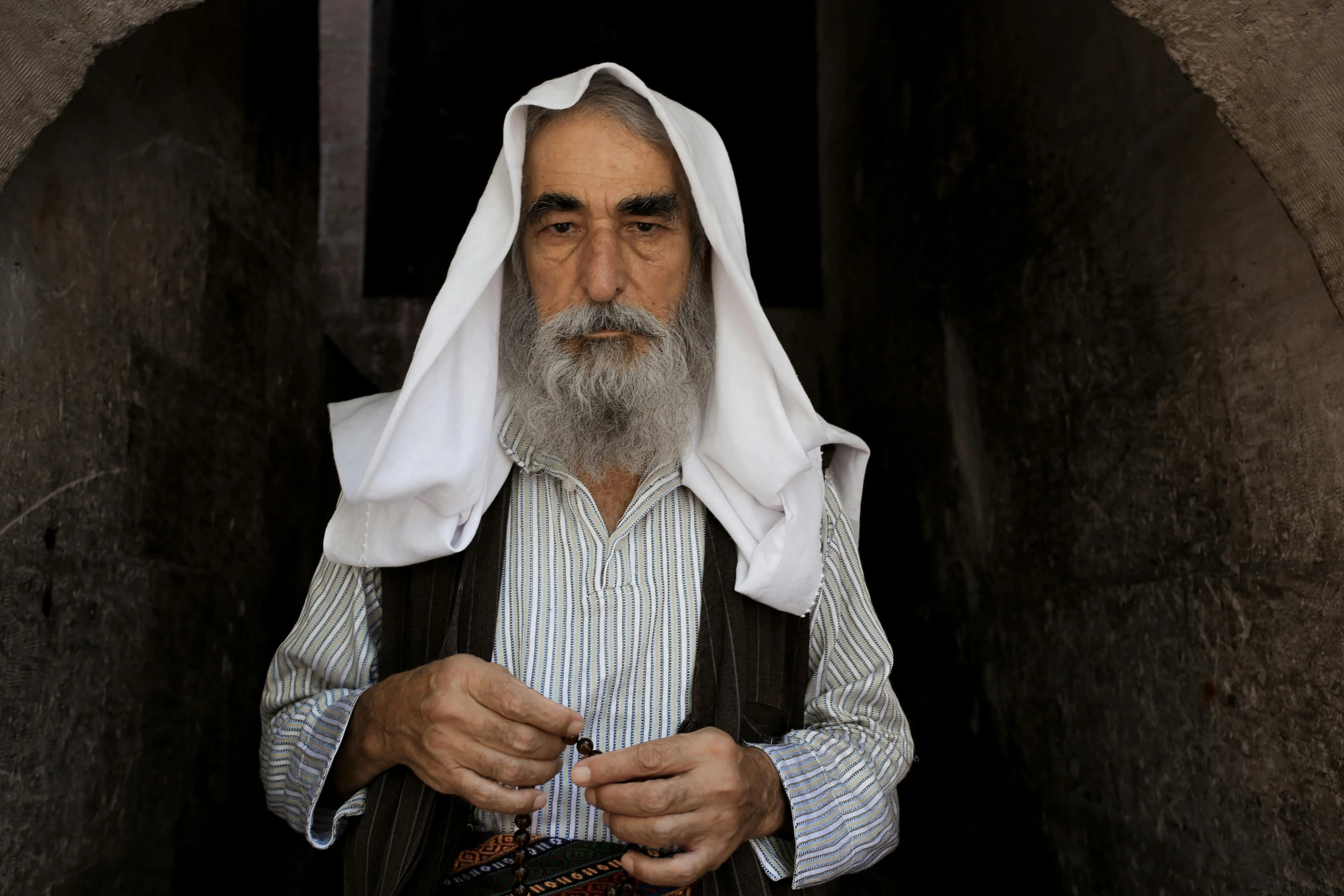 a man with a beard is wearing a white shawl