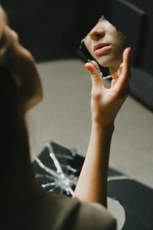 a woman on her cell phone is reflecting in a mirror