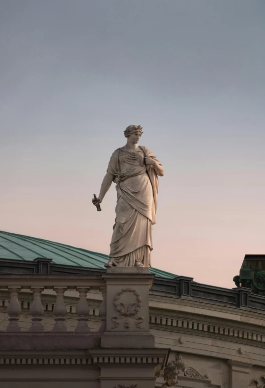 the statue stands on the top of a building