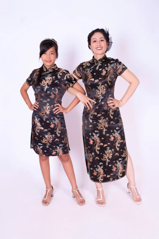 two asian women standing side by side wearing floral dress
