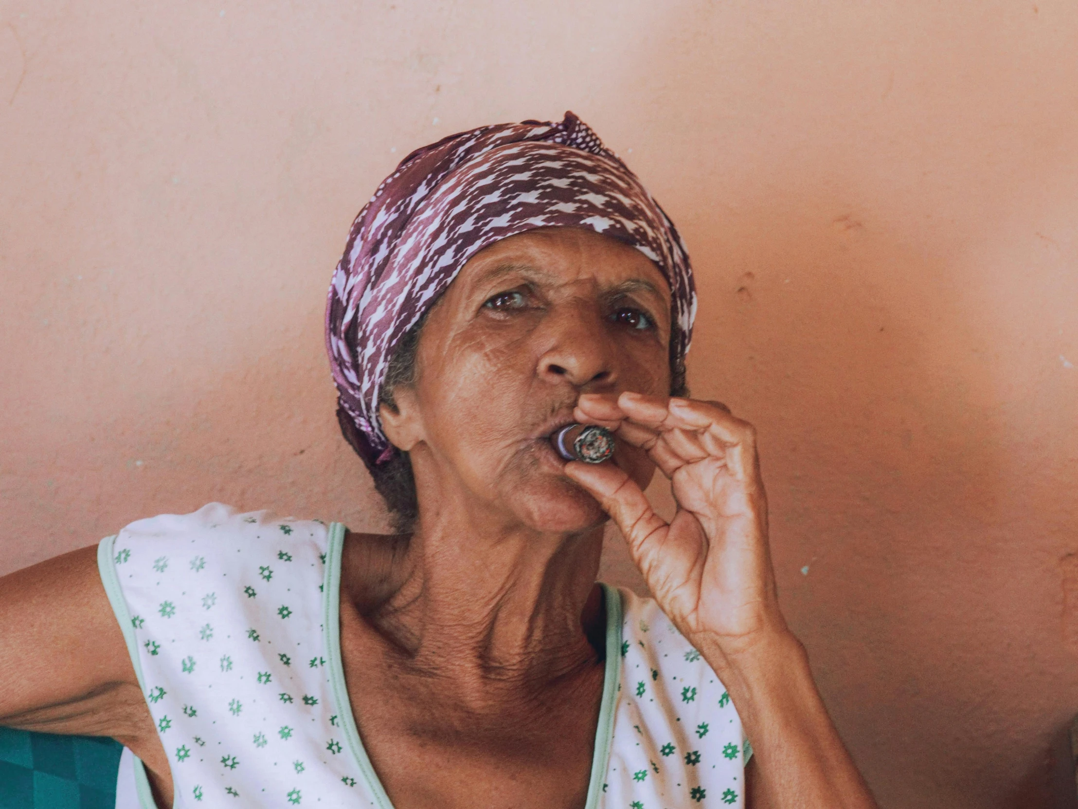 a woman sitting in the corner smoking a cigarette