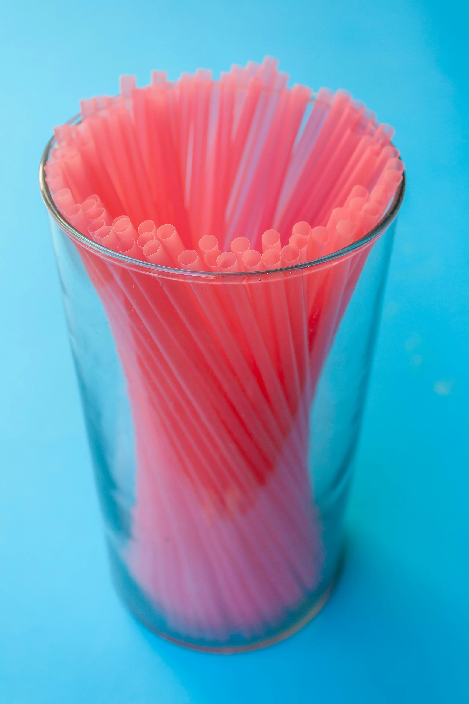 a cup that has many pink plastic straws inside of it