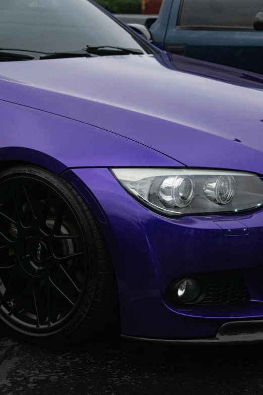 a purple bmw parked in front of two other cars