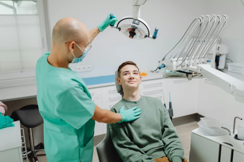 the dentist is smiling for the young patient to see