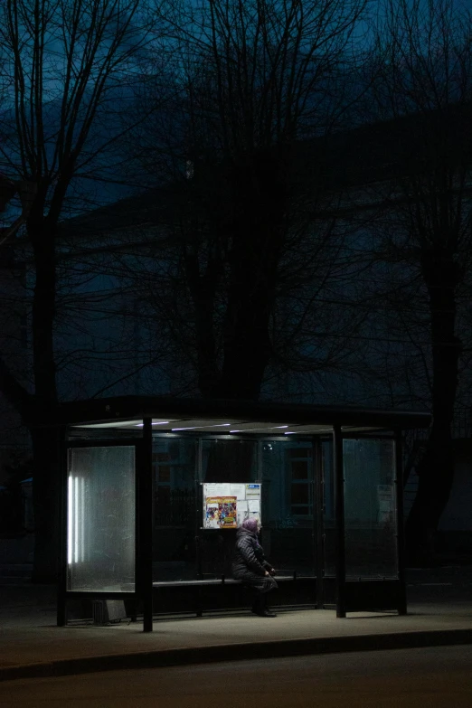 someone sitting inside of a shelter at night