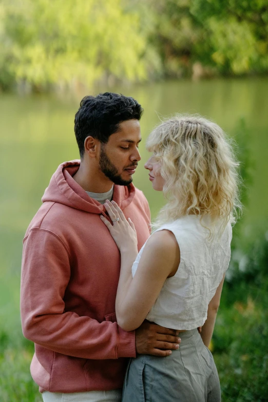 a man in a sweatshirt and woman facing each other