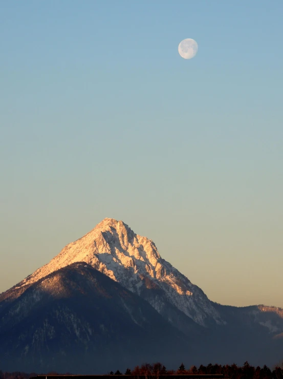 a large snow covered mountain under a blue sky