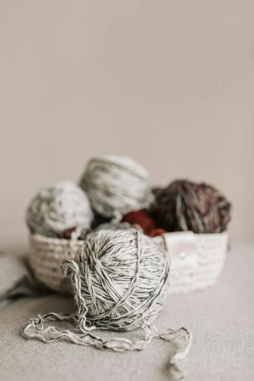 a white basket filled with balls of yarn