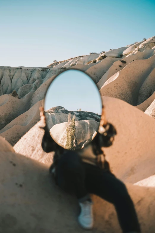 a person with their hand on the rock looking at soing