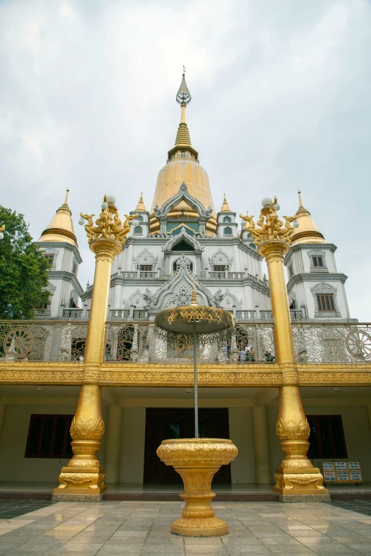 gold pillars and building with white wall and yellow dome