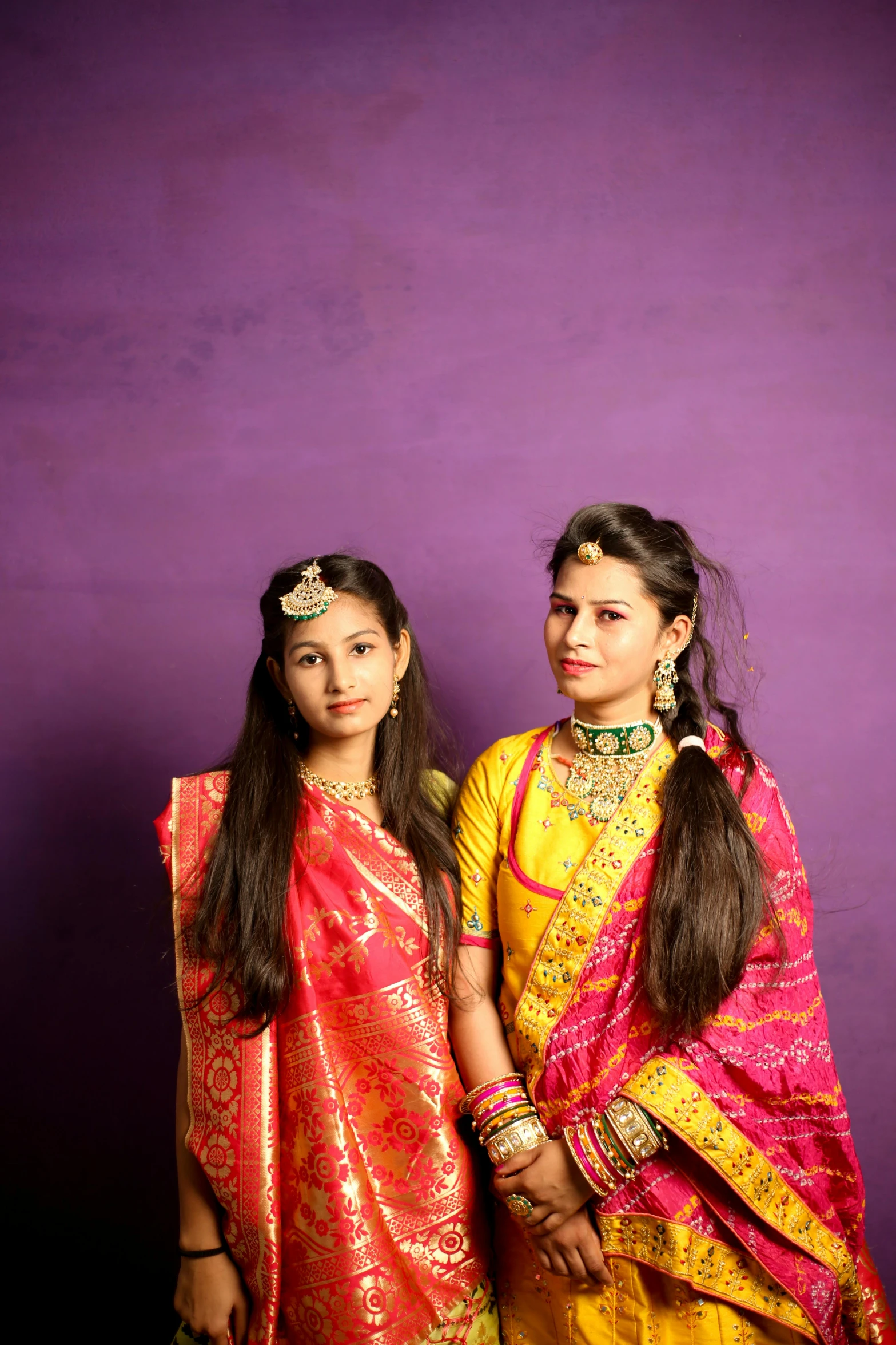 two girls dressed in different colors are posing together