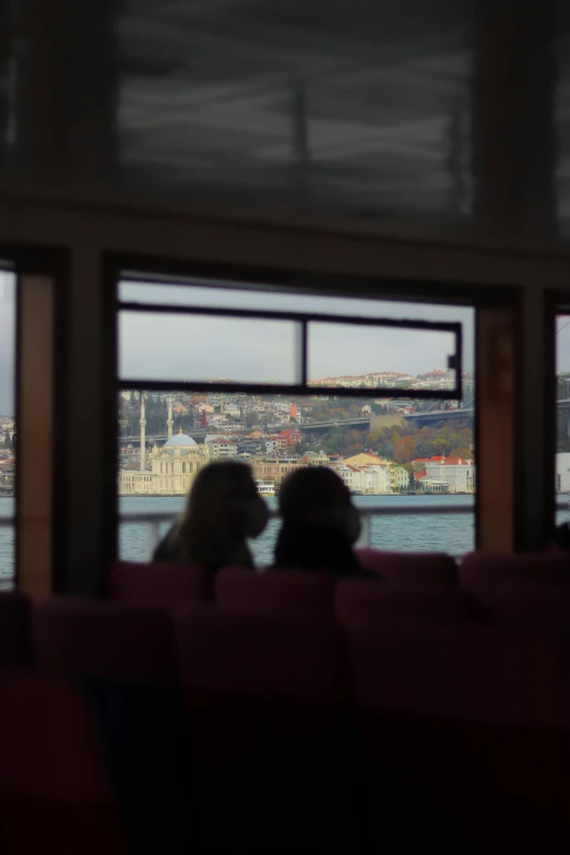 view out a window of a city, with the sea and mountains behind it