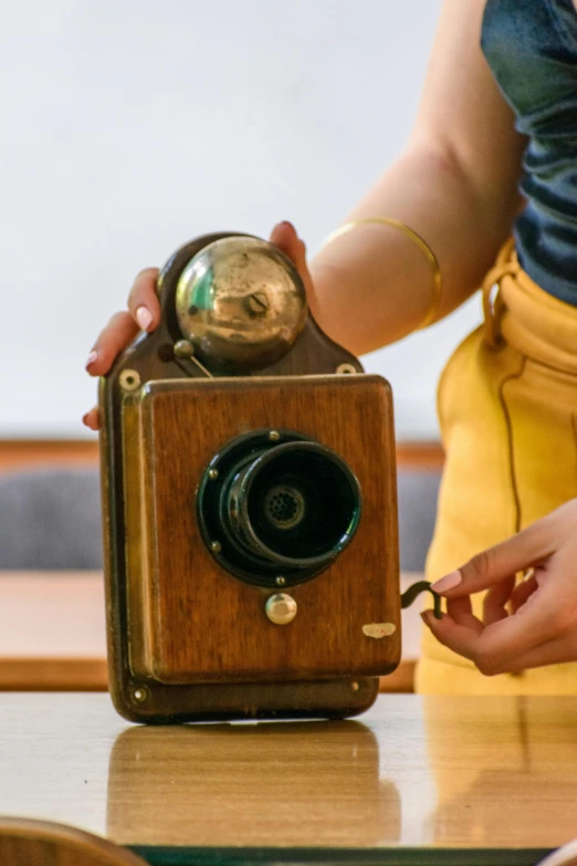 woman hands holding antique style camera on a table