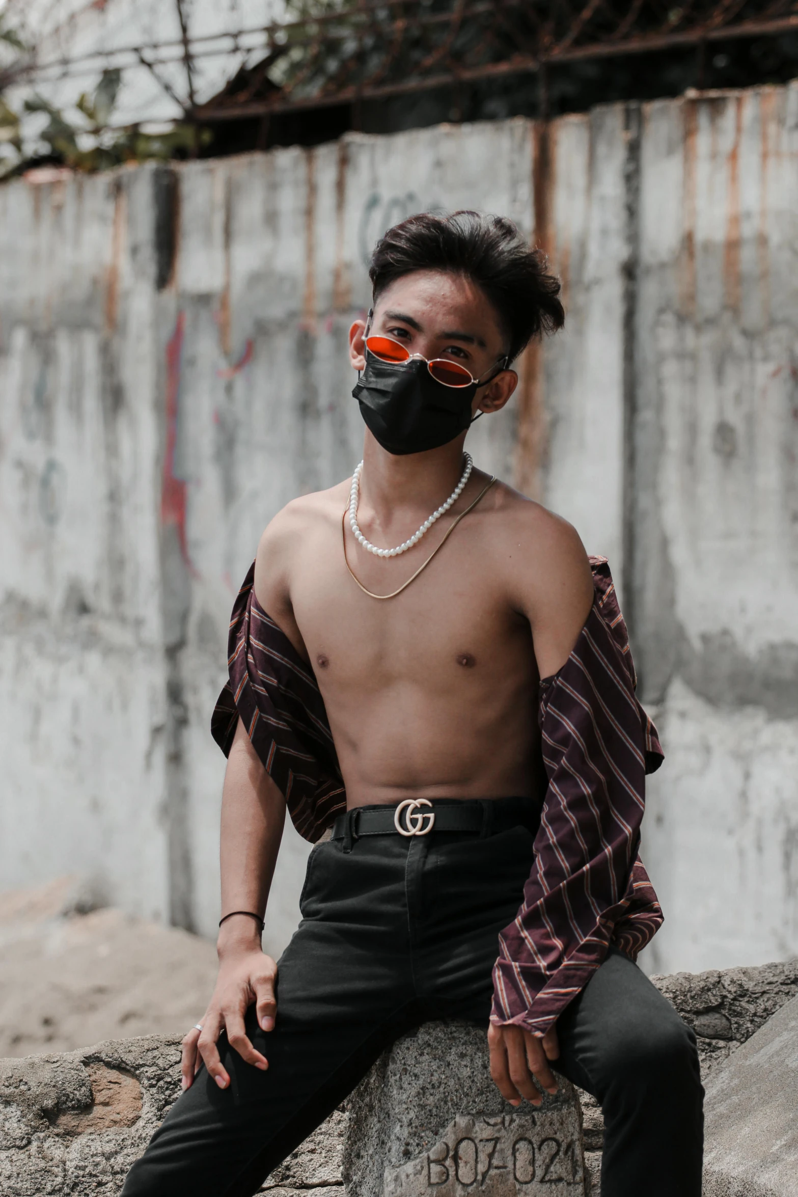 a young man wearing a mask and chain around his neck