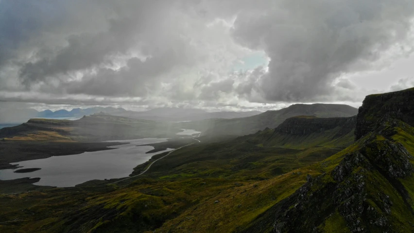 rain is falling down onto a lake with mountains in the background