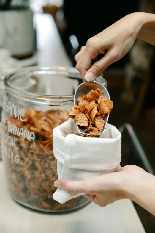 two hands placing chips in a small container