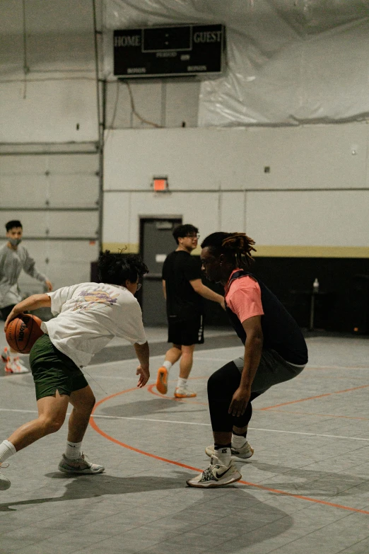 a group of s playing basketball together on an indoor court