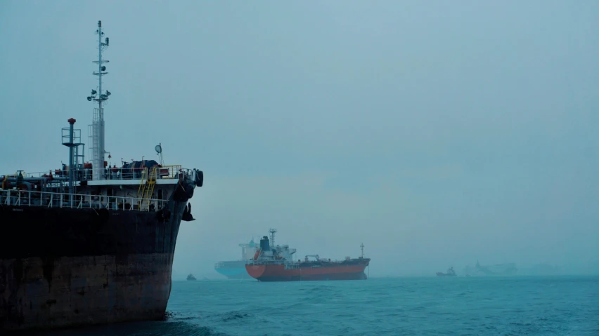 two boats on the water by the ship