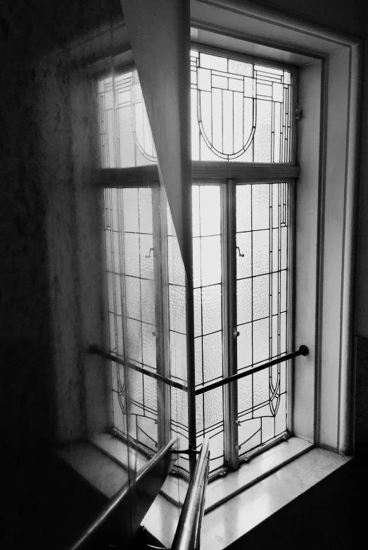 a window sitting next to a metal handrail on a wall