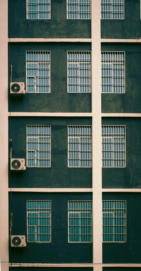 tall gray buildings with bars and window panes