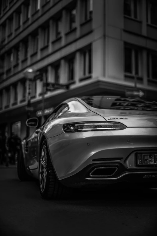 a silver sports car parked outside a building