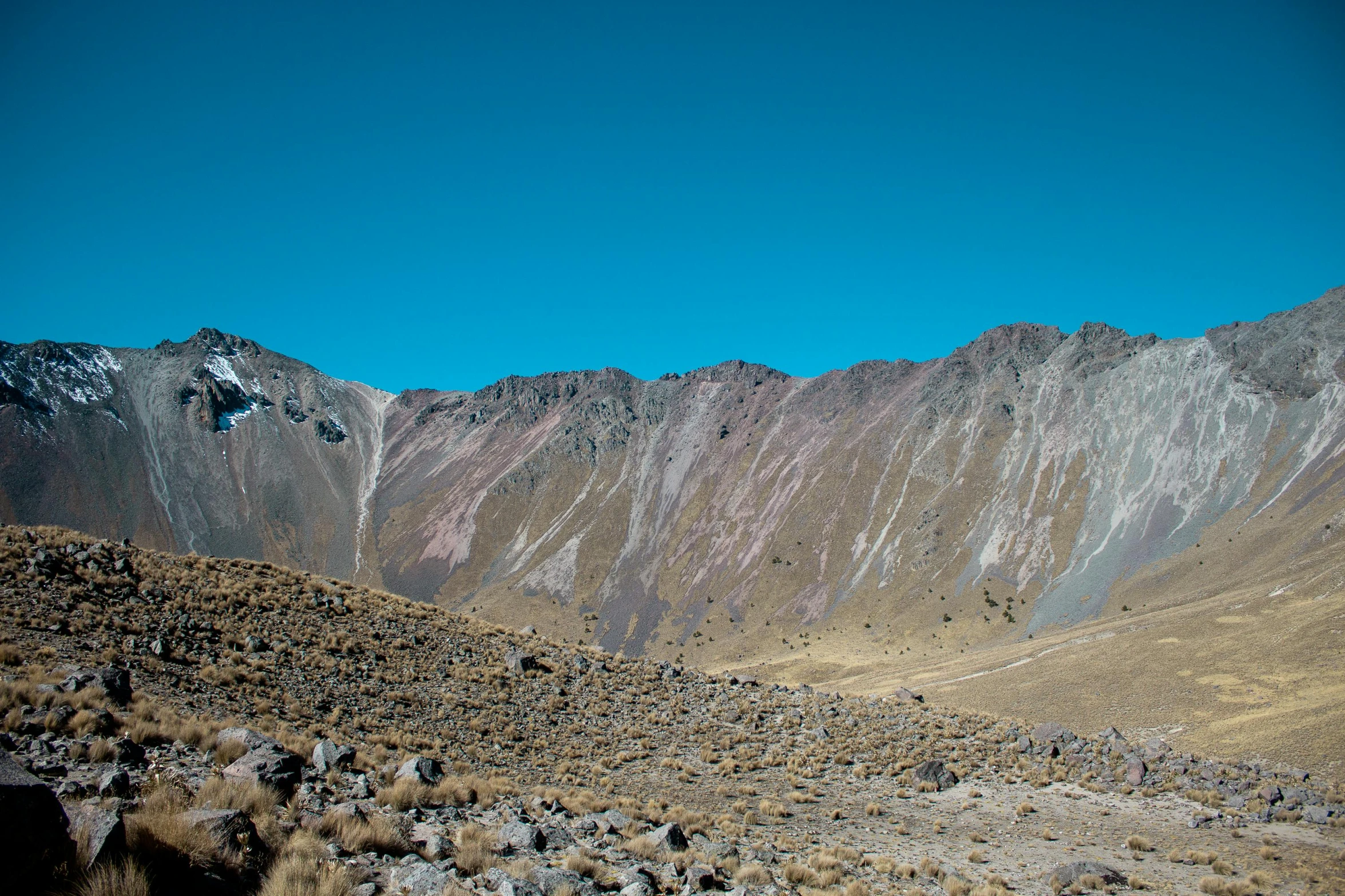 the mountains are tall and rocky against a bright blue sky