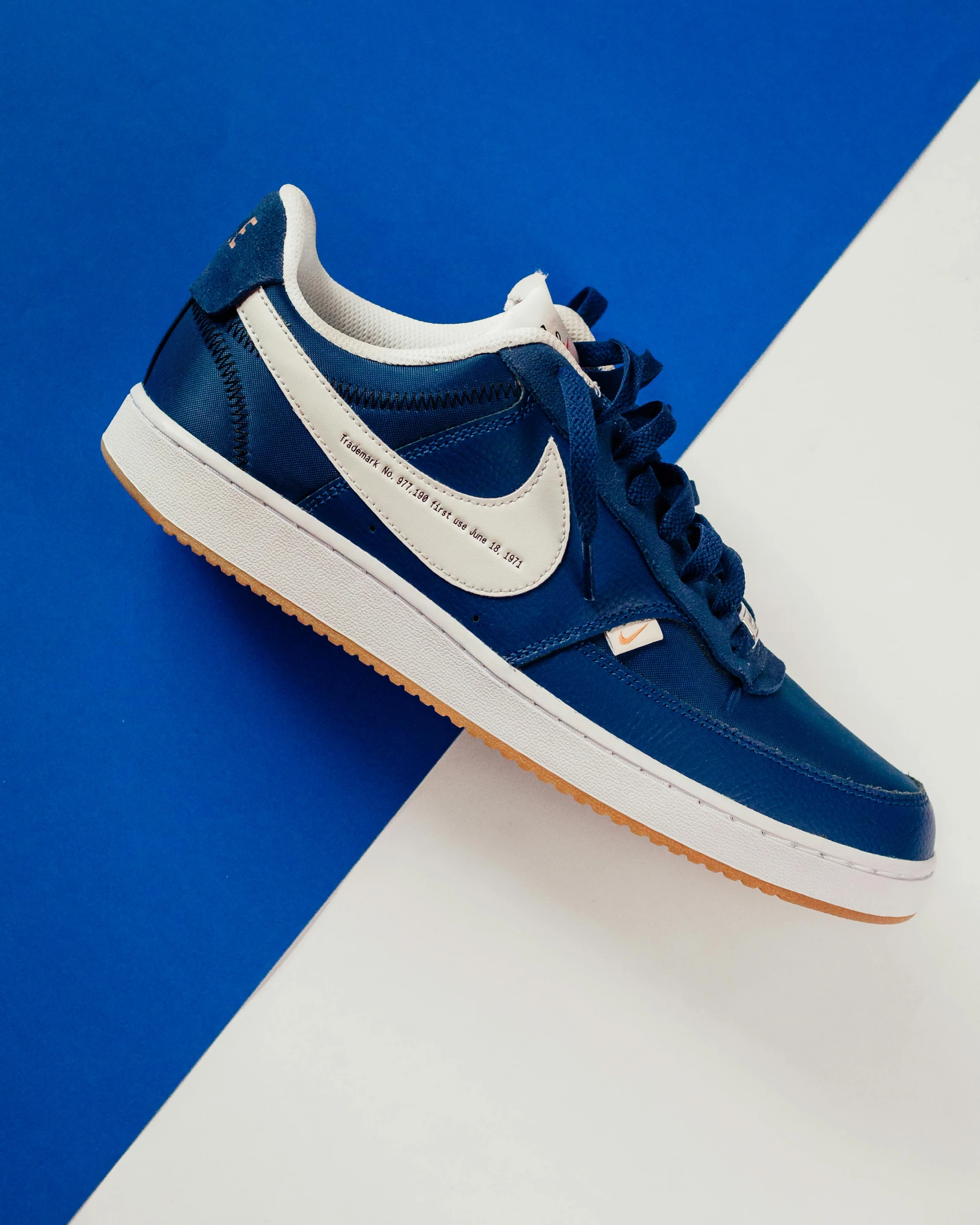 blue and white nike sneaker on a stripe