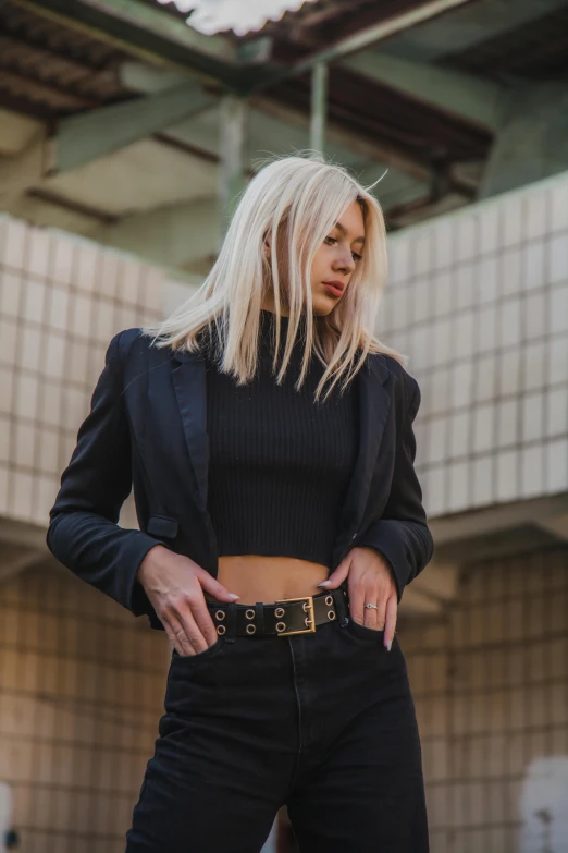 a woman with blonde hair wearing black and wearing jeans