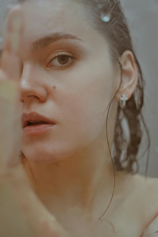 the woman is posing in front of a mirror and touching her face