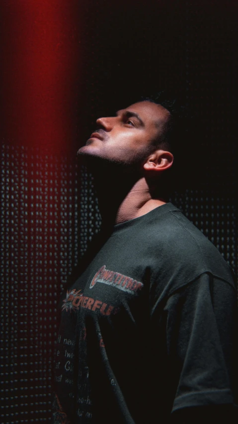 a male in a black shirt a light and some red lights