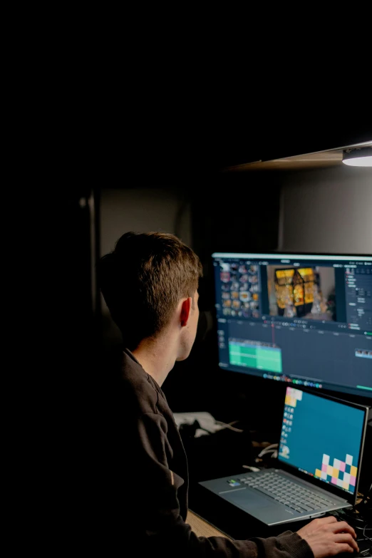 a person working on his computer in the dark