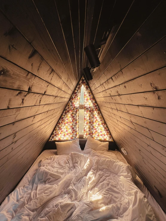 an attic bedroom with stained glass windows and bed