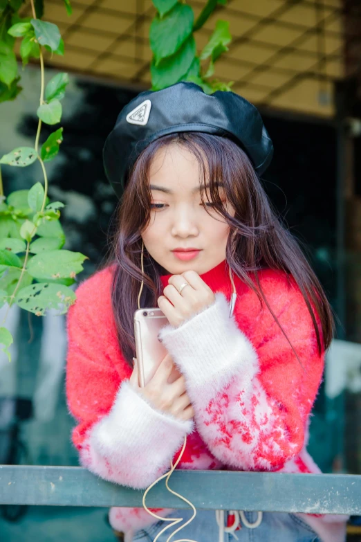 a young asian girl wearing a black hat and a sweater