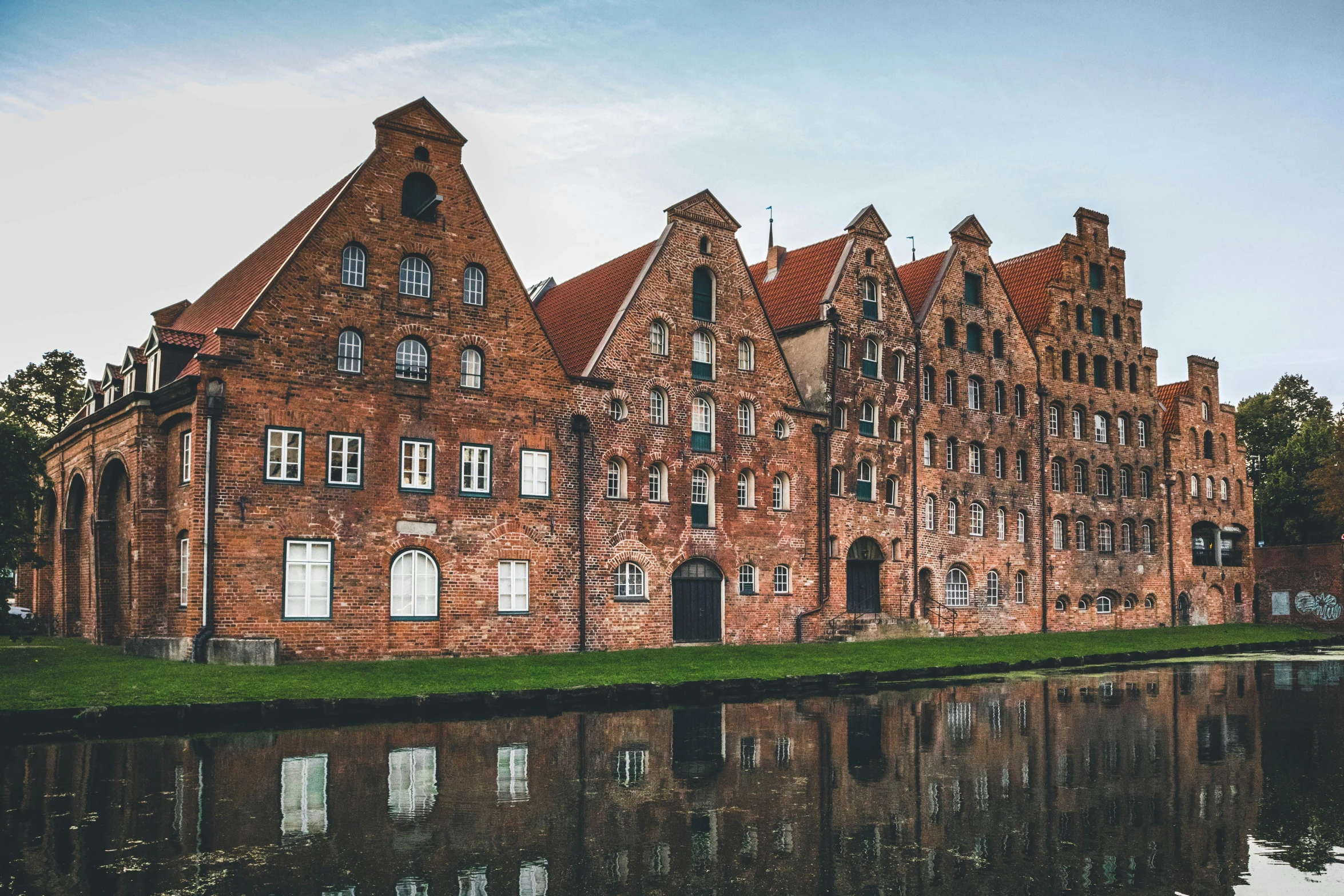 an old brick building is reflected in the water