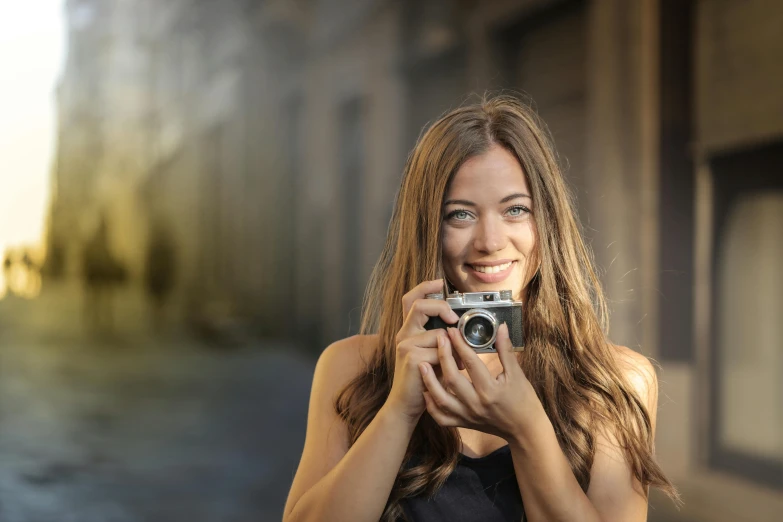 the woman is holding the camera and smiling