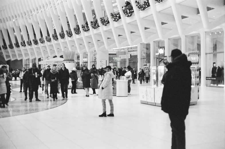 a crowd of people walking around an airport lobby