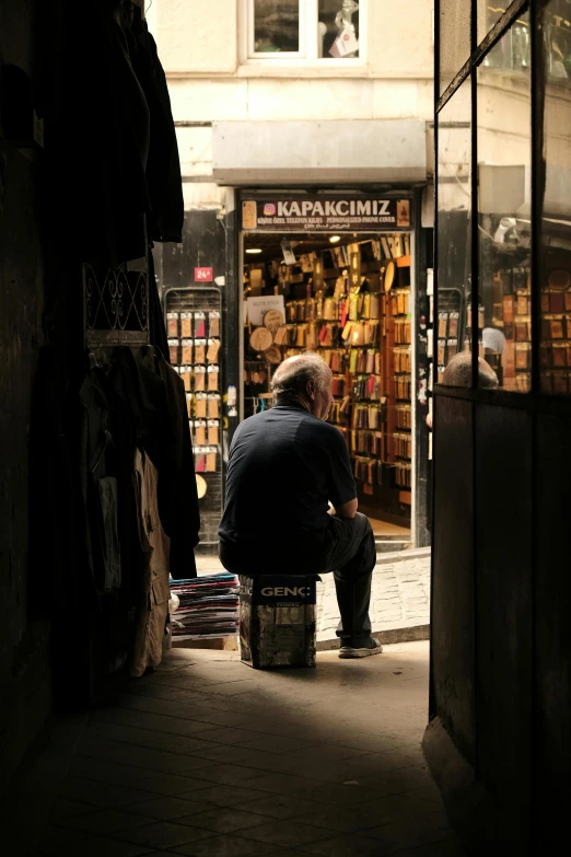 a man sitting on top of a barrel in front of a store