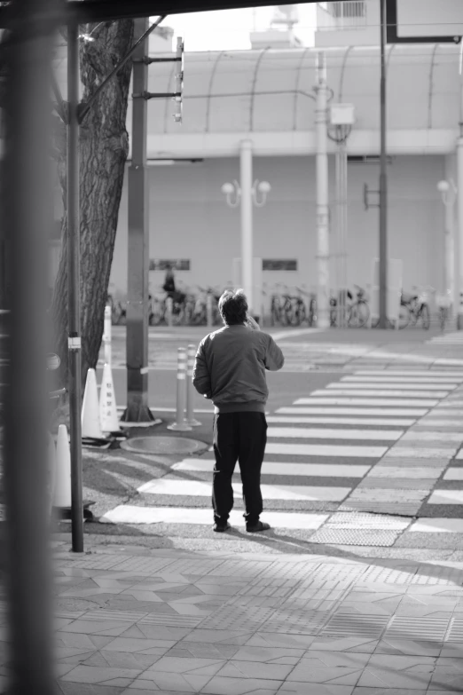 the man is standing alone in the crosswalk