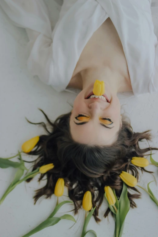 a person laying down on a bed with yellow flowers