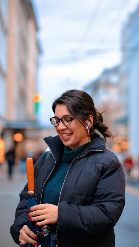 a woman standing on a city street and holding an umbrella