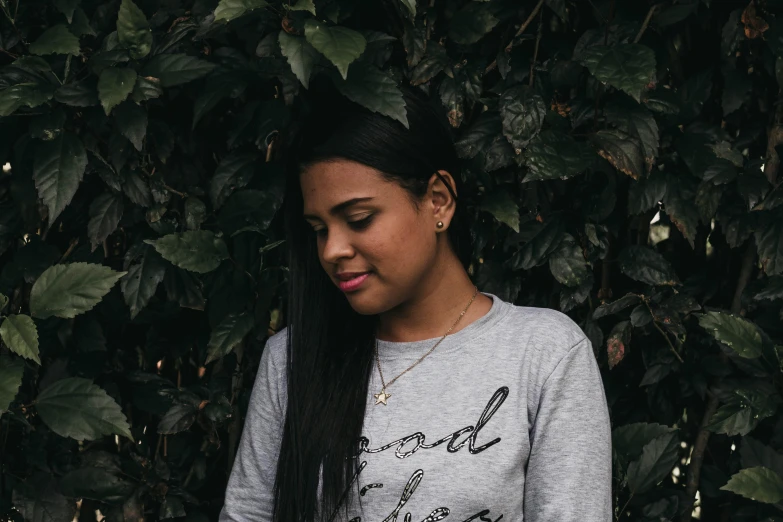 an attractive young woman with black hair and a shirt