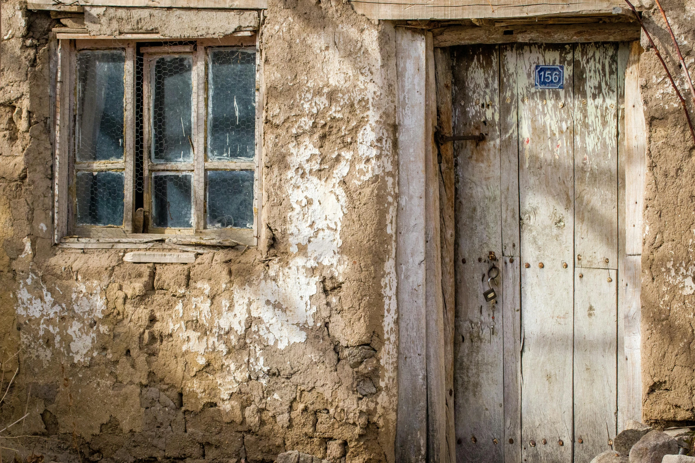 an old wooden door next to a dirty building