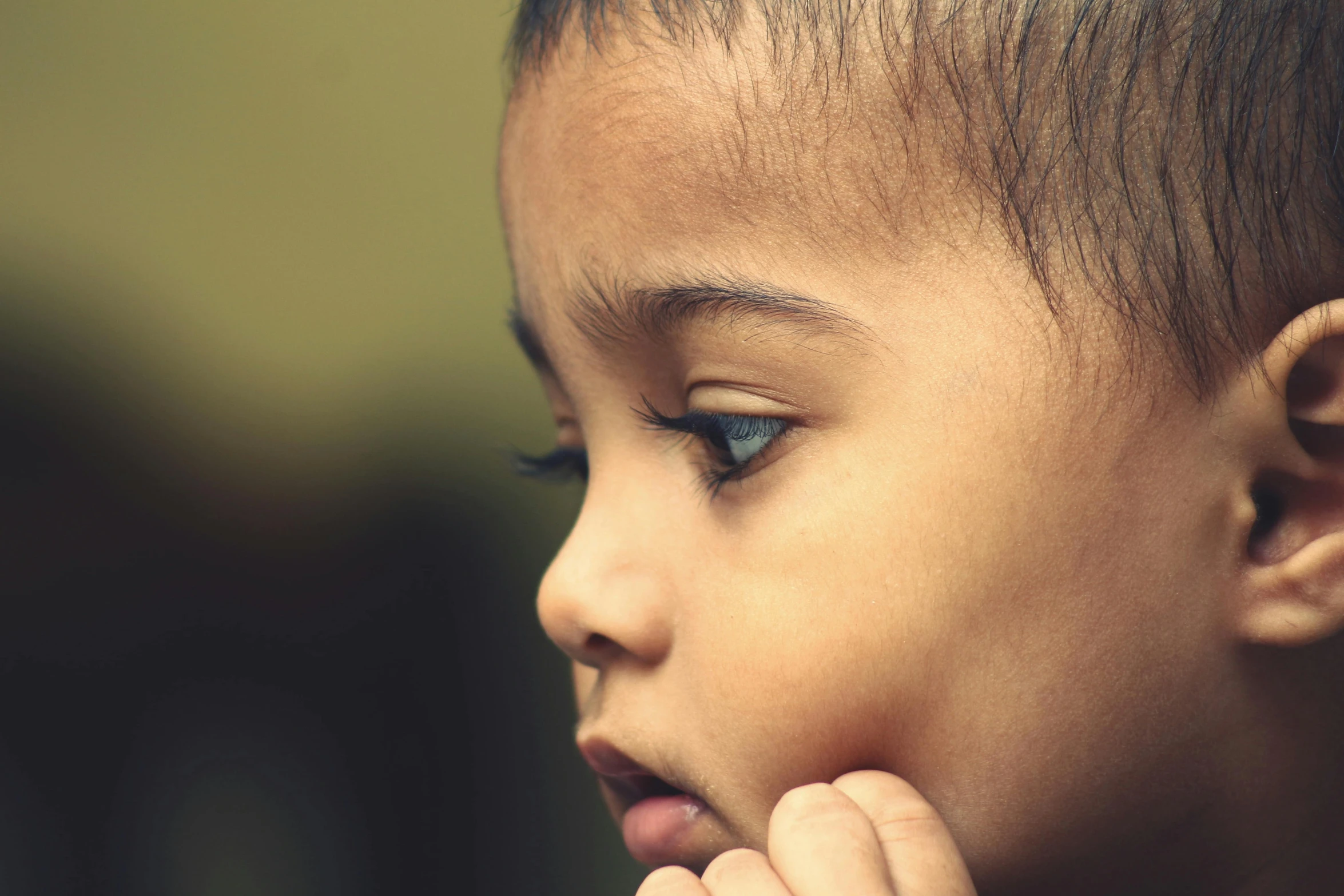 a child with blue eyes looks off to the left