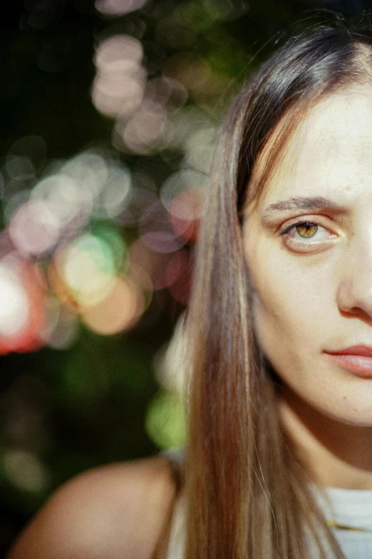 a close up of a woman's face with trees in the background